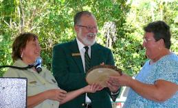 Constance Carpenter, left and Ariel Lugo present a plaque tto Marilyn Chakroff honoring her efforts on behalf of the forest.